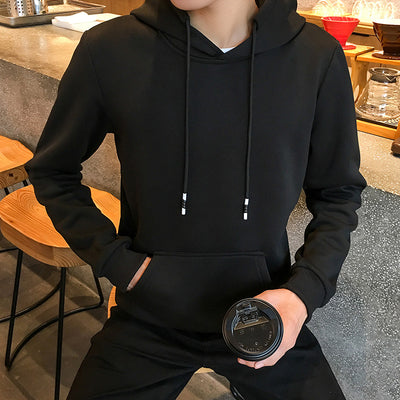 a man in a black hoodie holding a black object